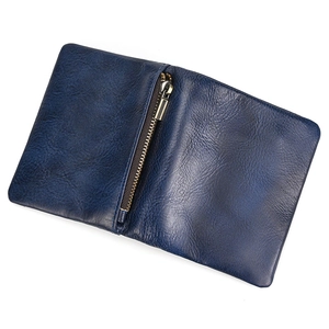 Deep blue leather bifold wallet detail showing vertical metal zipper pocket and texture