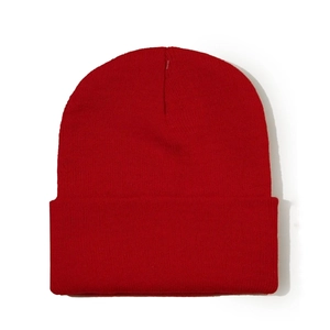 Détail du bonnet en maille rouge vif montrant la texture épaisse et le revers classique