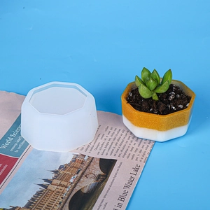 Dettaglio dello stampo in silicone esagonale con fioriera in resina su sfondo blu
