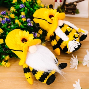 Detail von Strick-Bienen-Gnome mit Sonnenblumen-Mützen in einem Frühlingsgarten