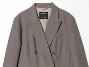 Detail of grey double-breasted blazer with peak lapels and branded inner neck label