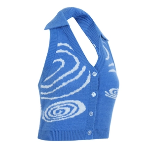 Dettaglio del top a lupetto in maglia blu con motivi a spirale bianchi e bottoni