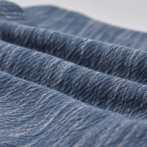 Macro detail of breathable blue pleated cotton fabric showing fine texture and softness
