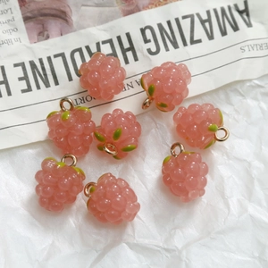 Detailed view of pink resin grape pendants with green leaves and gold metal rings