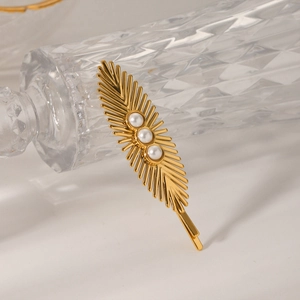 Detail of golden wheat ear hair clip with three white pearls on white background