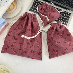 Detailed view of three corduroy drawstring bags in various sizes with vintage floral patterns