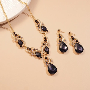 Luxurious gold jewelry set with purple teardrop crystals and sparkling rhinestones
