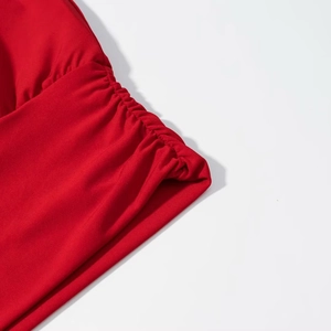 Détail du tissu froncé rouge montrant la texture et les coutures latérales froncées chic