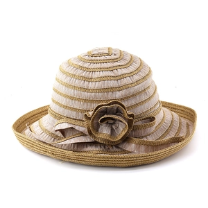 Détail d'un chapeau de paille rayé avec fleur 3D et texture tissée pour protection solaire