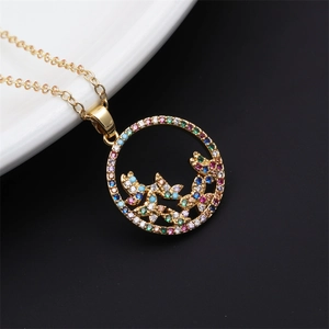 Detail of gold circular pendant with butterfly designs and colorful zircon stones