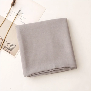 Detalle de bufanda gris de algodón y lino con textura mate suave y estilo minimalista