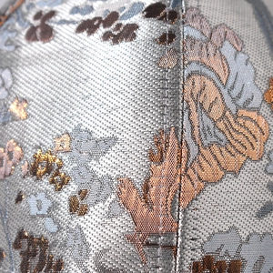 Macro detail of Chinese style floral brocade fabric with golden silk thread embroidery