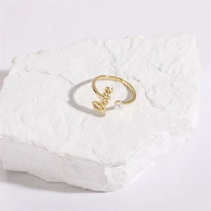 Detailed close-up of golden Love open ring with a white pearl on a natural stone base