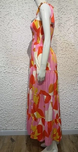 Detail of bohemian pink and orange floral maxi dress showing layered tiered skirt design