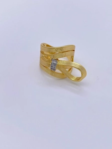 Macro shot of 18K gold plated bow ring with brushed texture and sparkling zircon stones
