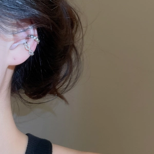 Close-up of silver zircon star and flower ear cuffs showing exquisite metal texture