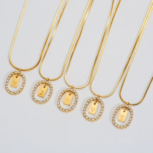 Gold plated stainless steel necklace with oval pavé diamond and letter pendants