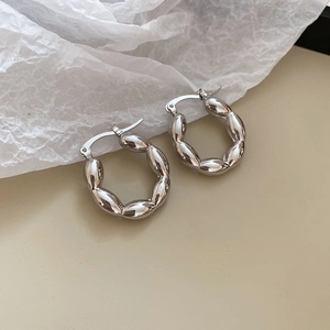 Detailed view of silver twisted croissant hoop earrings with a textured metallic finish