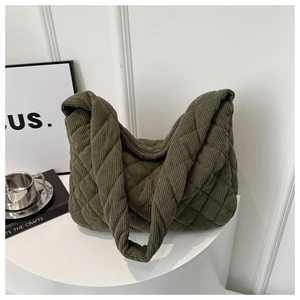 Army green quilted corduroy tote bag with diamond pattern on a white table