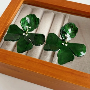 Close-up of green marble resin butterfly earrings with crystals in a wooden jewelry box