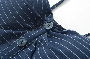 Détail du tissu à rayures bleu marine montrant la texture et les boutons assortis