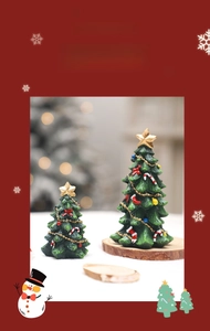 Detailed view of two green resin mini Christmas trees with gold stars and colorful ornaments