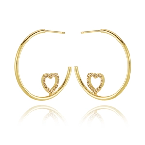 Macro detail of 18K gold plated heart hoops featuring shimmering cubic zirconia stones