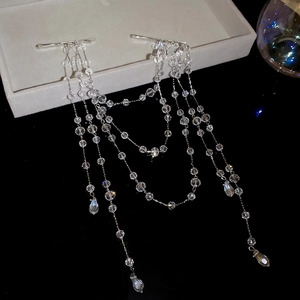 Detail of silver pearl fringe hair clip with crystal beads on a black reflective surface