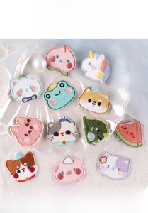 Detail shot of cute cartoon animal embroidered patches on a white shell plate