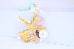 Close-up of golden starfish keychain with elegant shells, pearls, and colorful rhinestones