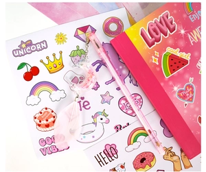 Close-up of pink glitter pen with feather pendant and colorful unicorn stickers