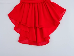 Detail of red sleeveless dress featuring layered ruffle hem and flowing chiffon fabric