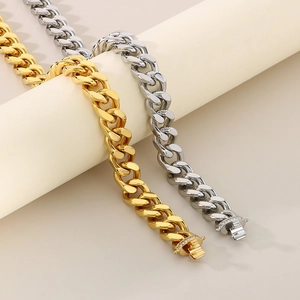 Detail of gold and silver Cuban link bracelets with iced out diamond clasp on stand