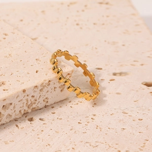 18K gold plated titanium steel ring with geometric jagged texture on travertine stone