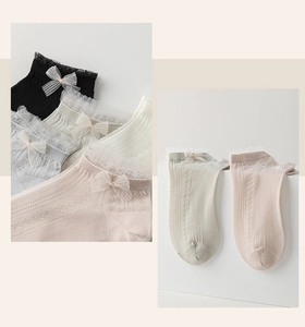 Detail of knit low-cut boat socks with delicate lace edges and sweet bow accents