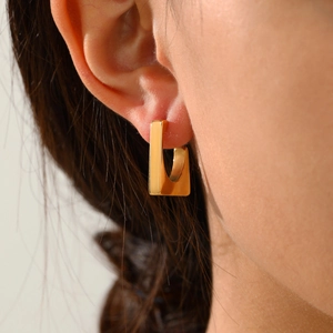 Close-up of a model wearing a geometric U-shaped 14K gold plated stainless steel earring