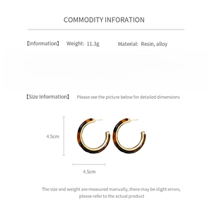 Detail view of resin tortoiseshell C-shaped hoop earrings with silver needles and size specs