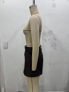 Détail de la jupe noire ajustée avec ceinture assortie vue de profil sur mannequin