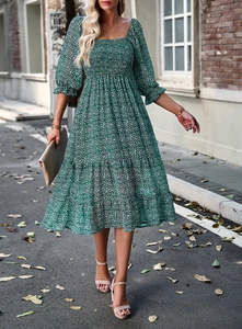 Detail of a green floral dress with a square neckline and elegant puff sleeves