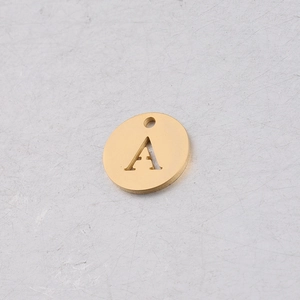 Détail d'un pendentif rond de 12mm en acier doré avec lettre A ajourée et fini miroir