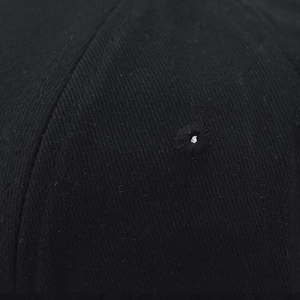 Close-up of cotton twill fabric showing detailed stitching and embroidered ventilation eyelet