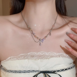 Detail of colorful crushed stone heart necklace with purple butterfly and zircon on skin