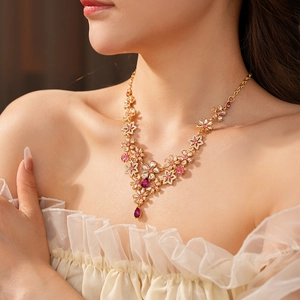 Detail of vintage gold-tone flower necklace with pink crystals worn by a model