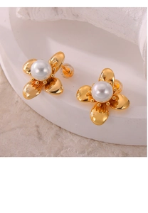 Detailed macro view of a gold flower earring with a centered white pearl inlay