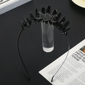 Macro view of gothic crown with black crystals and crescent moon symbols on metal band