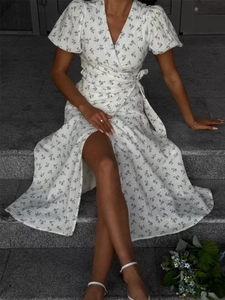 Close-up of white floral cotton wrap dress with short puff sleeves and waist tie detail