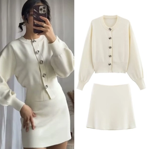Detalle del conjunto de punto con elegantes botones metálicos cuadrados y tela blanco crema