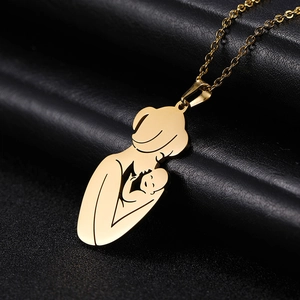 Macro shot of polished gold-tone mother and baby silhouette pendant on black leather