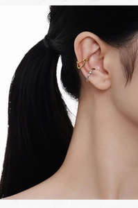 Detail view of gold V-shaped and silver textured S925 sterling silver ear cuffs on a model