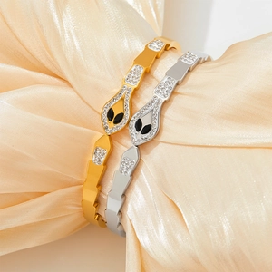 Gold and silver snake-shaped stainless steel bracelets with pavé crystals on silk fabric